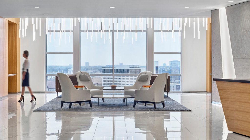 A person walking in a room with a large window.